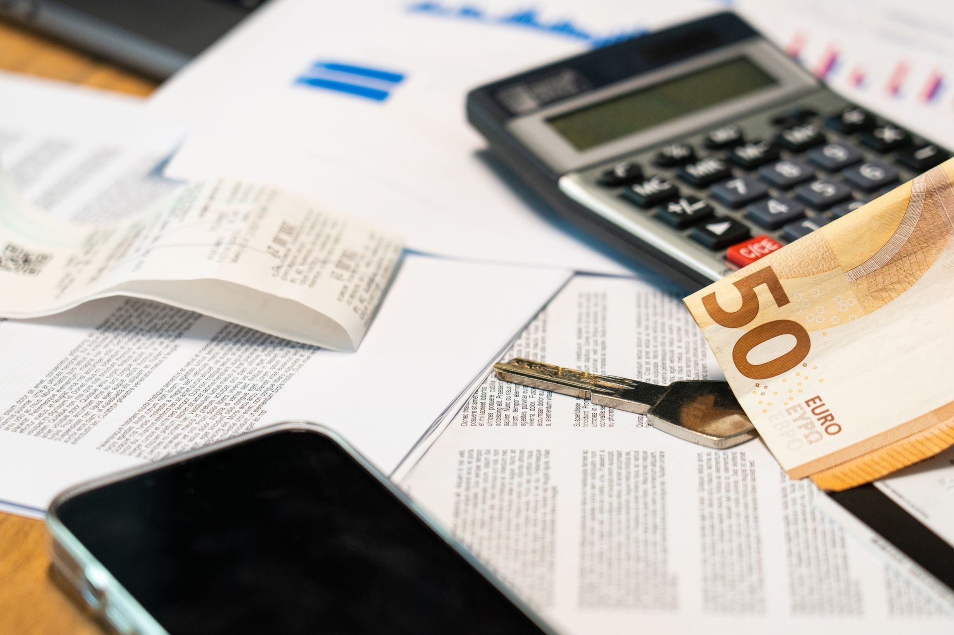 Calculadora y billetes de euro sobre documentación para calcular el coste de un IEE