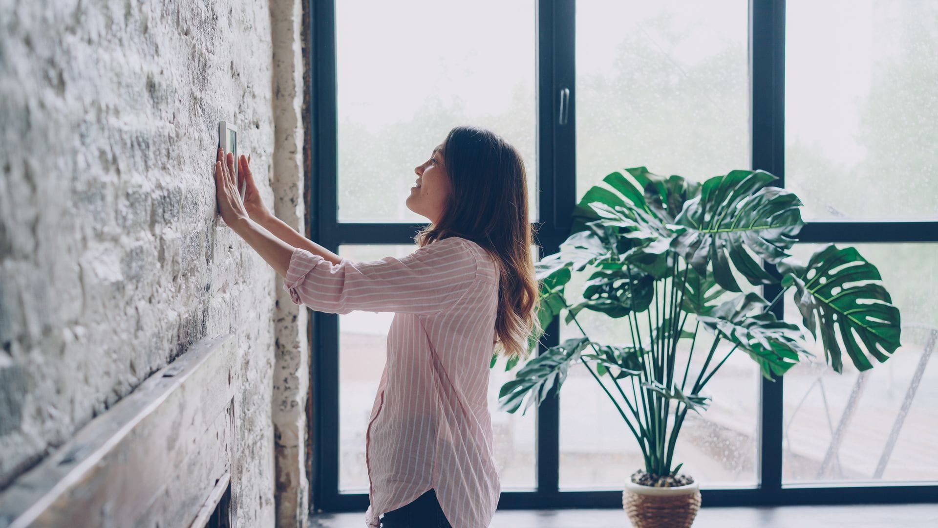 Persona ajustando el termostato en una vivienda con buena eficiencia energética